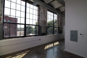 A room with large windows and a brick wall.