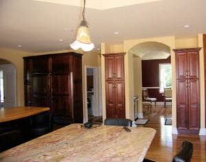 An interior of the house with a dining table and brown cupboards